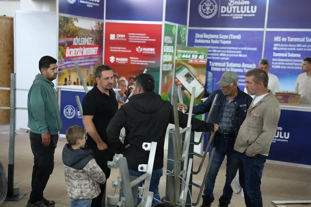 Bir stantta ürünleri inceleyen ziyaretçi grubu